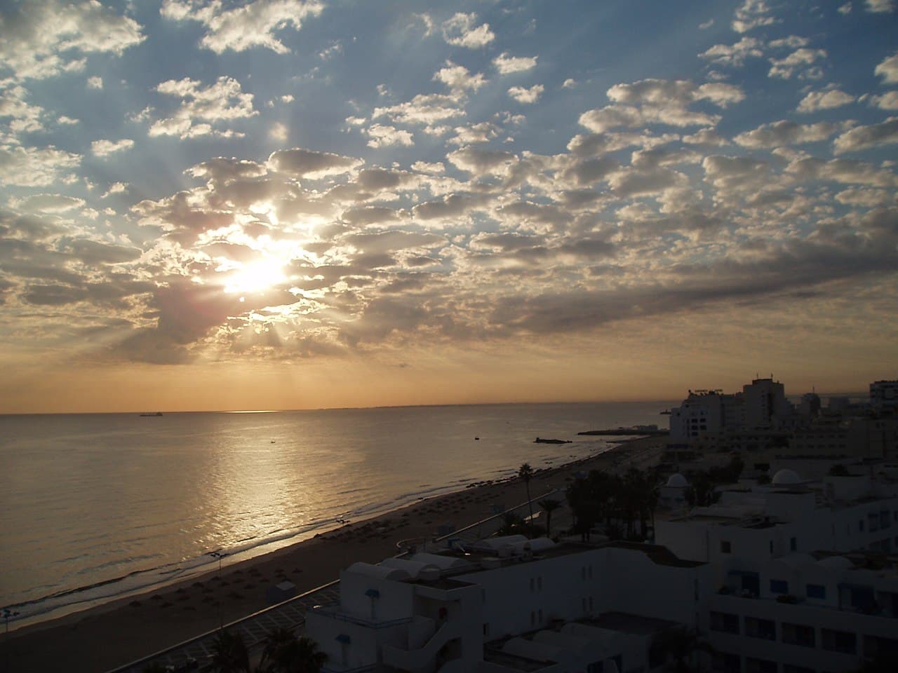 Coucher de soleil flamboyant sur la baie de Sousse, vu des toits
