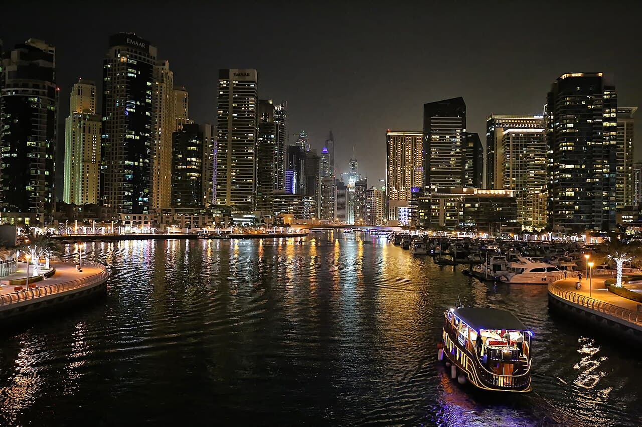 Marina illuminée la nuit, yachts et tours scintillantes