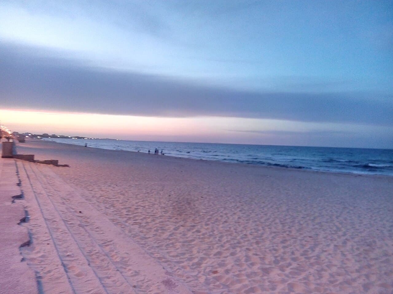 Plage de la corniche Boujaafar à l'heure bleue, sable rosé et mer calme