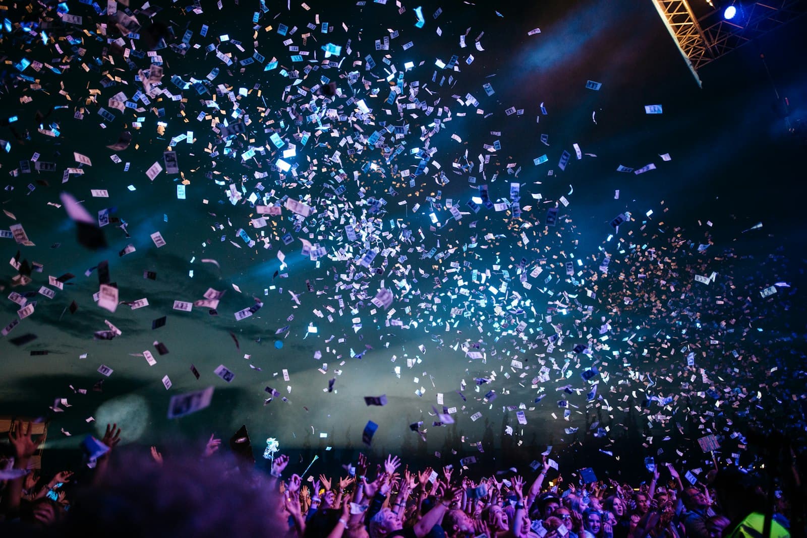 Pluie de confettis sur une foule en fête sous les lumières de la nuit